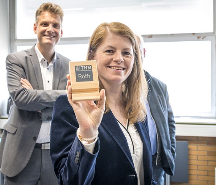 Smartphone-Zubehör der Zukunft: Dr. Anne-Kathrin Roth von den Stiftungsunternehmen erhält die bahnbrechende, autonom produzierte Handyhalterung bei der Demonstration. (Foto: Technische Hochschule Mittelhessen)